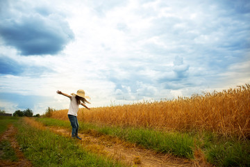 Little girl is spinning on a wheat field. Positive emotions and energy. Happy childhood.