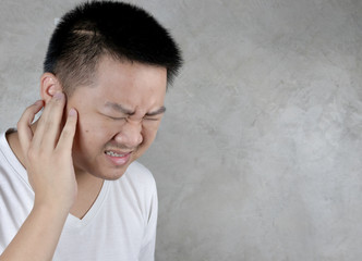Asian men use hands to close their ears. Showing pain, having problems with the health of the ears isolated on gray background healthcare and medical concept