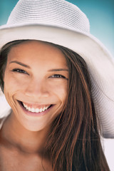 Asian woman smiling happy portrait in summer beach wearing sun hat. Beauty young girl closeup face toothy smile with perfect teeth.