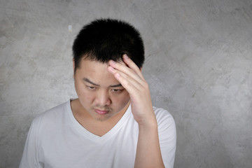 Portrait Young Asian men unhappy Use the handle on the head showing headaches, stress, migraines isolated on gray background Health concept