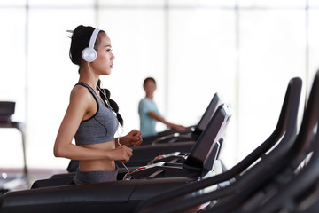 Fitness woman wearing headphone cardio workout at fitness gym.