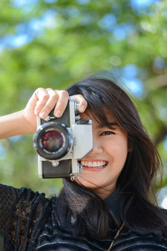 Young asian woman holding a classic camera