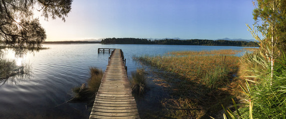 old narrow wooden jetty jutting out across the lake