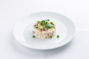 Russian traditional salad Olivier with parsley isolated on white background