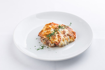 Baked meat with tomato and mayo cheese sauce isolated on white background