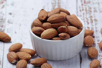 A small bowl with almond at white background