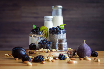 Organic natural breakfast, consists of yogurt with chia, berries, nuts, summer fruits on table....