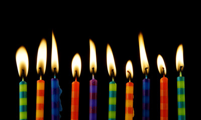 Burning birthday candles on black background