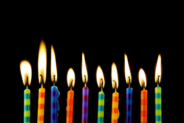 Burning birthday candles on black background