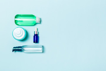 Cosmetics SPA branding mock-up, top view with copy space. set of tubes and jars of cream flat lay on blue background