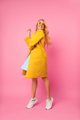 Young Girl Posing in Coat, Having Fun on Pink Background