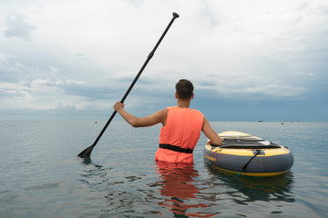 StandUp Paddleboarding. Sup Surfer in life jacket and surfboard with paddle. Close up