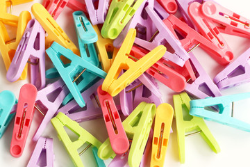 Collection of colorful plastic clothes pin on white background.