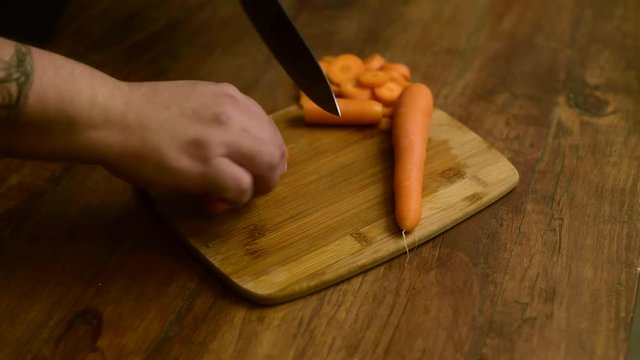 manos cocinando cortando con cuchillo zanahorias