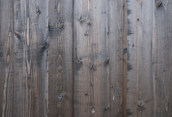 Background from old wood texture. Softwood boards. Annual rings and cuts from branches (knots) Beautiful, natural pattern. Summer, sunny day.