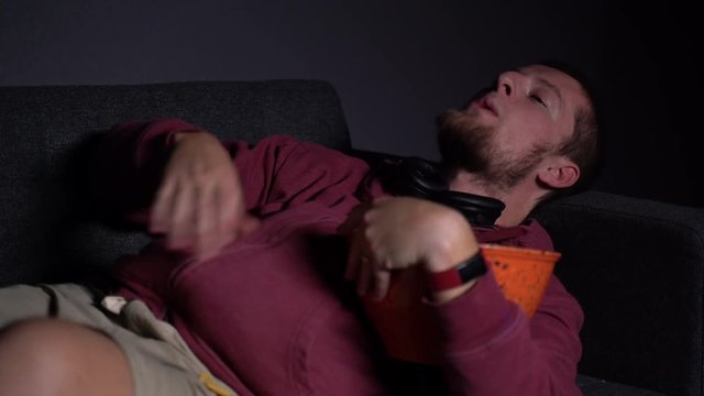 Overweight Caucasian Adjusting his Position on Sofa and being Lazy Watching TV
