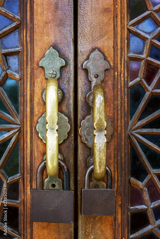 Wall mural decorative antique wooden door with two metal locks close up on building in sheki, azerbaijan