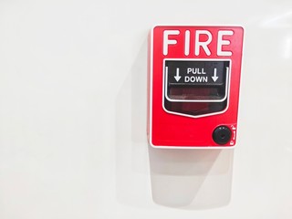 Red fire alarm on the white wall 
