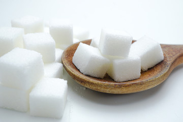 Sugar sweet cubes high calories in wooden spoon : fat diet healthy food concept.