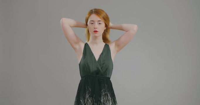 young redhead beauty doing hair in front of mirror