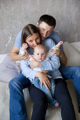 Fototapeta premium Happy Young Caucasian Family Sitting on Bed
