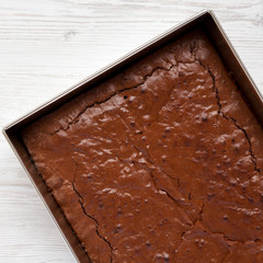 Homemade chocolate brownie on a white wooden table, top view. Overhead, from above, flat lay. Close-up.