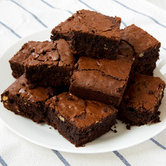 Homemade chocolate brownies on a white plate, side view. Close-up.