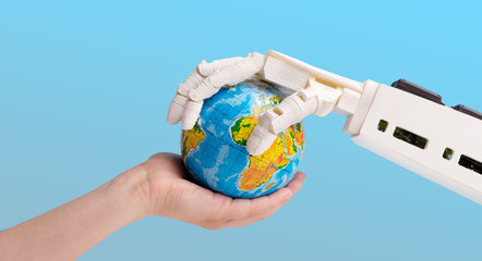 Human and robot hands holding earth globe