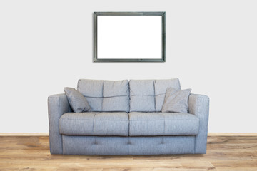 Interior of living room with sofa or couch furniture on wooden floor and mockup art frame isolated with white wall background