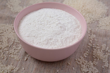 Gluten free rice flour in a pink bowl, side view. Close-up.