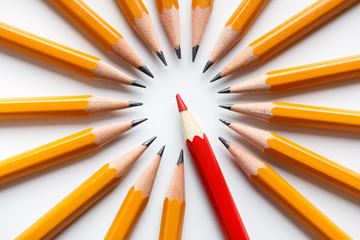 Group of classic yellow pencils surrounding red leader © Prostock-studio