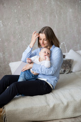 Caucasian Mother and Daughter Sitting on Bed