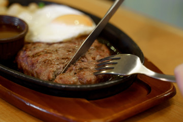 レストランでハンバーグを切るナイフとフォークのアップ