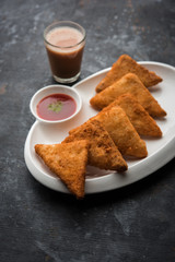crispy Potato triangles or batata vada covered with bread crumbs and then deep fried. served with tomato ketchup. selective focus