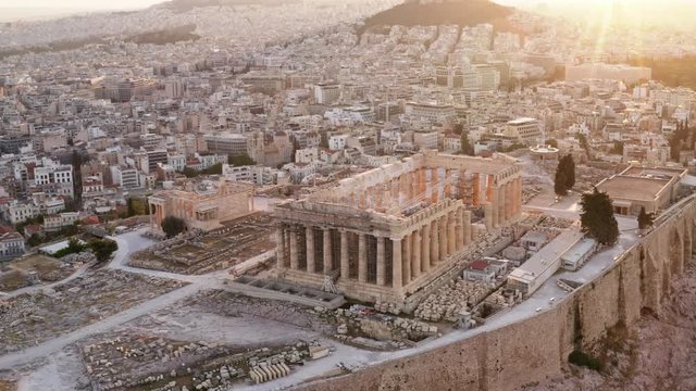 Aerial view of a slide from the drone on the panorama of residential buildings of the city of Athens, on the main symbol of ancient Greece, Acropolis at sunrise. The lights sun. World Heritage sites