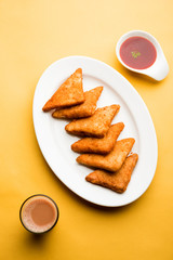 crispy Potato triangles or batata vada covered with bread crumbs and then deep fried. served with tomato ketchup. selective focus