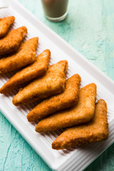 crispy Potato triangles or batata vada covered with bread crumbs and then deep fried. served with tomato ketchup. selective focus