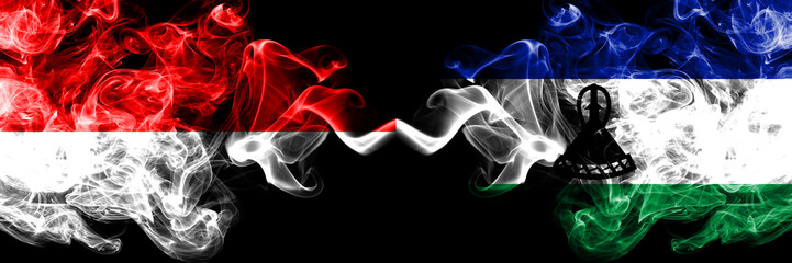 Indonesia vs Lesotho smoky mystic flags placed side by side. Thick colored silky smoke flags of Indonesia and Lesotho