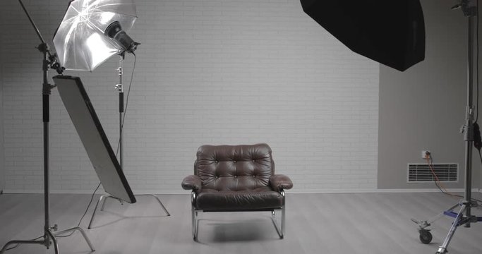Photo studio with leather chair, c-stand, bouncing desk and octabox / steady cam moving shot