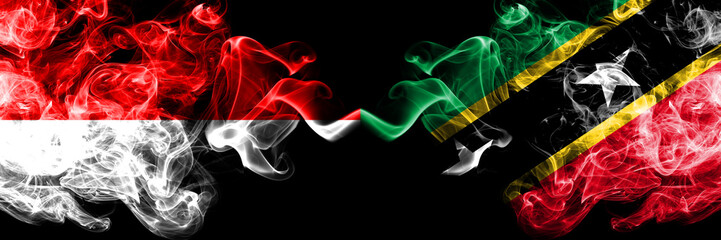 Indonesia vs Saint Kitts and Nevis smoky mystic flags placed side by side. Thick colored silky smoke flags of Indonesia and Saint Kitts and Nevis