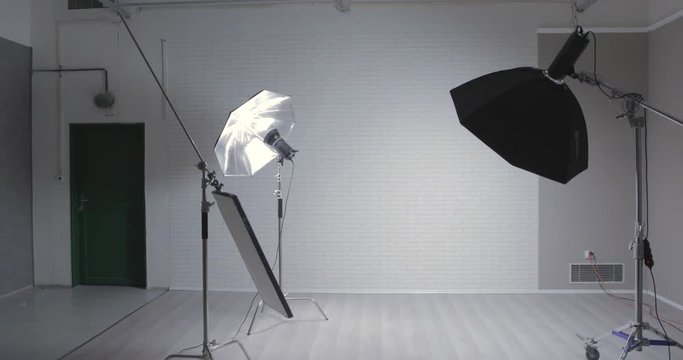 Empty photo stuid with c-stand, bouncing desk and octabox / jib moving shot