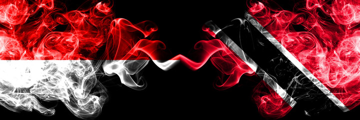 Indonesia vs Trinidad and Tobago smoky mystic flags placed side by side. Thick colored silky smoke flags of Indonesia and Trinidad and Tobago