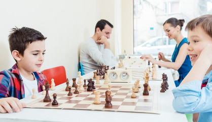 Family playing chess in tournament room