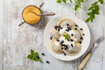 Delicious dumplings with fresh blueberries served with whipped cream and sugar or sauce.