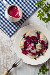 Delicious dumplings with fresh blueberries served with whipped cream and sugar or sauce.