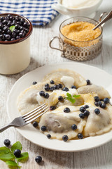 Delicious dumplings with fresh blueberries served with whipped cream and sugar or sauce.