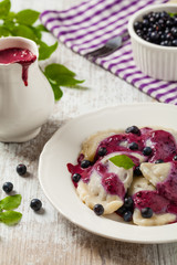 Delicious dumplings with fresh blueberries served with whipped cream and sugar or sauce.