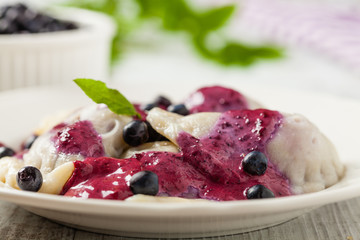 Delicious dumplings with fresh blueberries served with whipped cream and sugar or sauce.