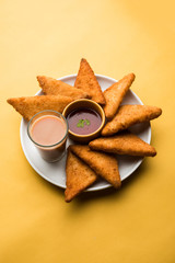 crispy Potato triangles or batata vada covered with bread crumbs and then deep fried. served with tomato ketchup. selective focus