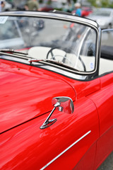 Chrome mirror veteran red cabriolet.